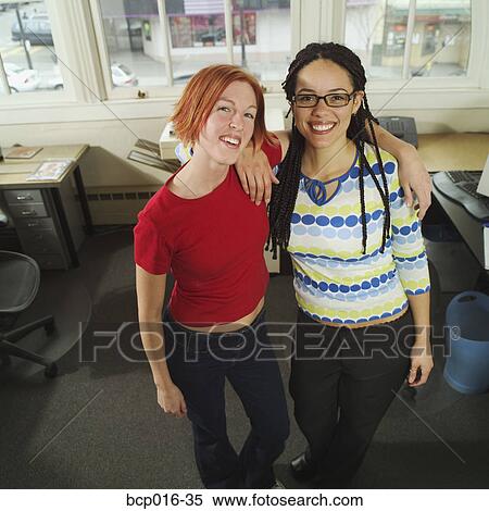 Stock Photography - Young co-workers in an office. . Fotosearch