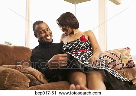 A couple cuddling on the sofa. View Large Photo Image Stock Image - A couple cuddling on the sofa.. Fotosearch