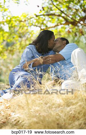A couple kissing in the park. View Large Photo Image Stock Photo - A couple kissing in the park.. Fotosearch