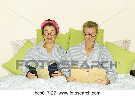 A couple reading together in bed and wearing matching pajamas. View Large Photo Image Stock Photo - A couple reading together in bed and wearing matching pajamas.. Fotosearch