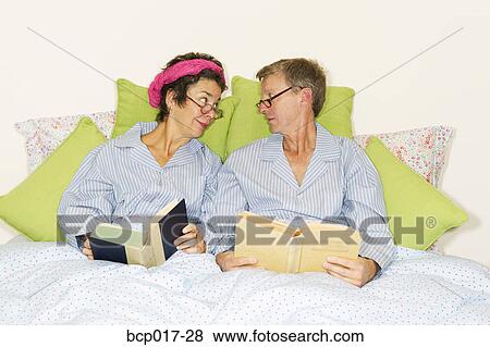A couple reading together in bed and wearing matching pajamas. View Large Photo Image Stock Photo - A couple reading together in bed and wearing matching pajamas.. Fotosearch