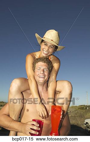 A young woman riding on her boyfriend's shoulders. View Large Photo Image Stock Photography - A young woman riding on her boyfriend's shoulders.. Fotosearch