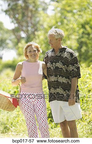 Couple strolling in the park with picnic basket. View Large Photo Image Stock Photo - Couple strolling in the park with picnic basket.. Fotosearch