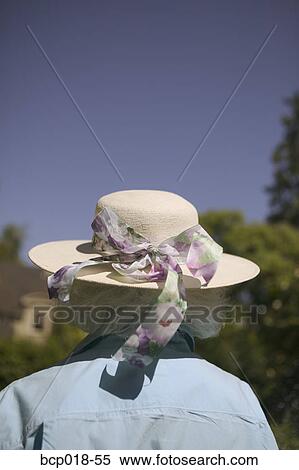 Rear view of a woman wearing a hat with a ribbon. View Large Photo Image Stock Photography - Rear view of a woman wearing a hat with a ribbon.. Fotosearch