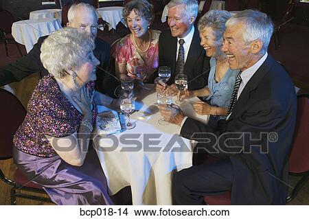 Picture - Senior couples talking at a nightclub table.. Fotosearch