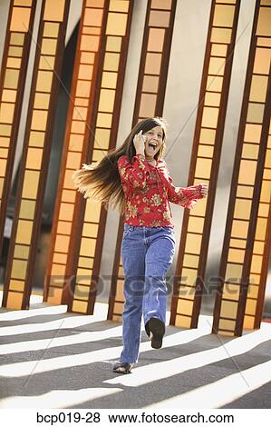 Girl kicks up her feet while chatting on a mobile phone. View Large Photo Image Stock Photo - Girl kicks up her feet while chatting on a mobile phone.. Fotosearch