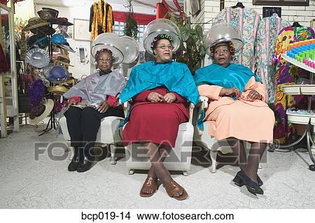 Picture - Three senior women sitting under hairdryers.. Fotosearch