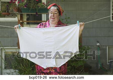 Woman behind a huge pair of underwear on a clothesline. View Large Photo Image Stock Photograph - Woman behind a huge pair of underwear on a clothesline.. Fotosearch