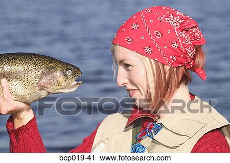 Woman going eye to eye with a large trout. View Large Photo Image Stock Image - Woman going eye to eye with a large trout.. Fotosearch