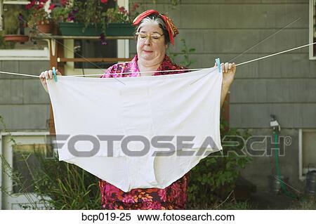 Woman hanging oversized underwear on a clothesline. View Large Photo Image Stock Photography - Woman hanging oversized underwear on a clothesline.. Fotosearch