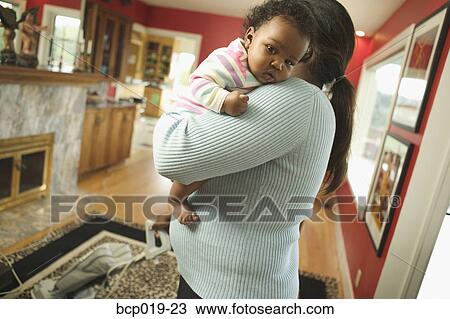 Woman holds baby while vacuuming. View Large Photo Image Stock Image - Woman holds baby while vacuuming.. Fotosearch