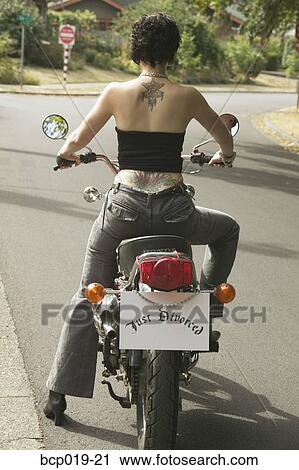 Stock Image - Woman on motorcycle with a "Just Divorced" sign.. Fotosearch