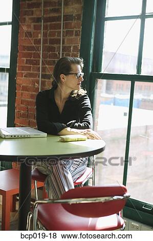 Woman with laptop looking out a window. View Large Photo Image Stock Photo - Woman with laptop looking out a window.. Fotosearch