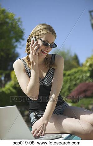 Young woman outdoors with laptop and cell phone View Large Photo Image Stock Photo - Young woman outdoors with laptop and cell phone. Fotosearch
