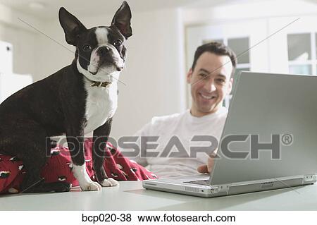 Stock Photo - A man and his dog, work on a laptop computer.. Fotosearch