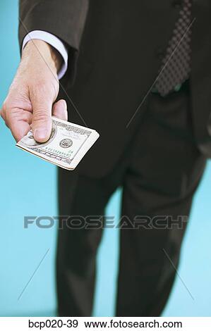 A man in a suit offering money. View Large Photo Image Stock Photo - A man in a suit offering money.. Fotosearch