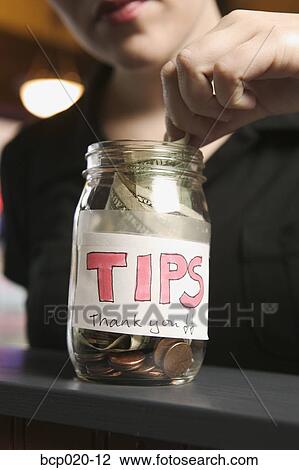 Stock Image - Close-up of a tip money jar.. Fotosearch