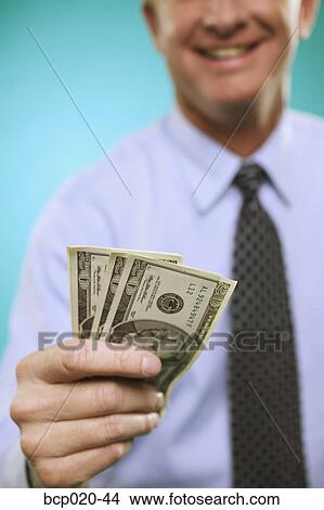 Close-up of man offering money. View Large Photo Image Picture - Close-up of man offering money.. Fotosearch