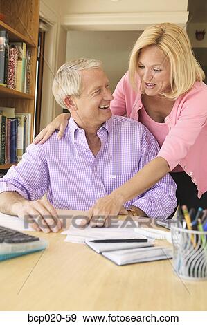 Couple working on paying bills in a home office. View Large Photo Image Stock Photo - Couple working on paying bills in a home office.. Fotosearch