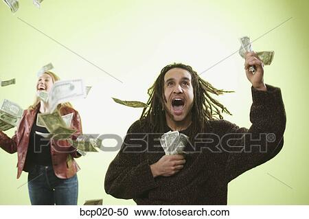 Stock Image - Man and woman catching falling money.. Fotosearch