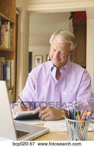 Man writing checks in his home office. View Large Photo Image Stock Photo - Man writing checks in his home office.. Fotosearch