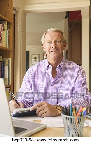 Man writing checks in his home office. View Large Photo Image Stock Photo - Man writing checks in his home office.. Fotosearch