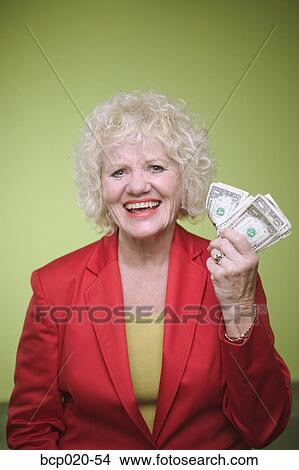 Senior woman holding a handful of money. View Large Photo Image Picture - Senior woman holding a handful of money.. Fotosearch