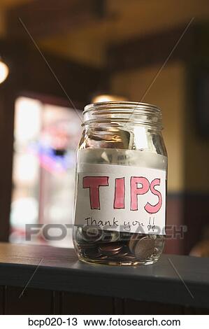 Still life of a full tip jar. View Large Photo Image Stock Image - Still life of a full tip jar.. Fotosearch