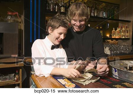 Two restaurant workers counting cash on the bar top. View Large Photo Image Stock Photography - Two restaurant workers counting cash on the bar top.. Fotosearch