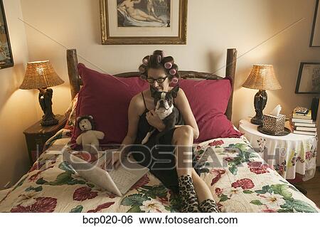 Woman in bed with her dog while working on personal finances. View Large Photo Image Stock Photograph - Woman in bed with her dog while working on personal finances.. Fotosearch