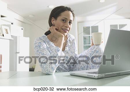 Woman in pajamas working at a laptop computer. View Large Photo Image Stock Image - Woman in pajamas working at a laptop computer.. Fotosearch