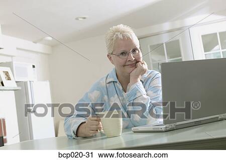 Woman working on a laptop in her pajamas. View Large Photo Image Stock Image - Woman working on a laptop in her pajamas.. Fotosearch