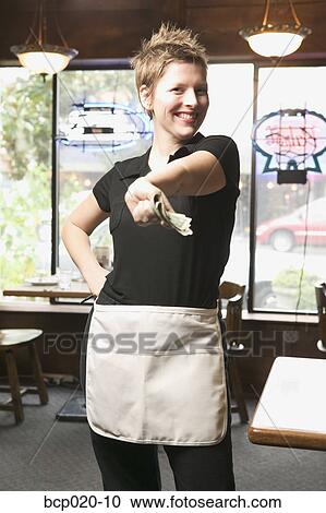Young waitress holding out money. View Large Photo Image Stock Image - Young waitress holding out money.. Fotosearch