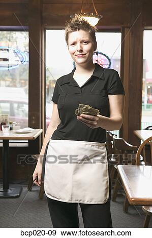 Young waitress holding out money. View Large Photo Image Stock Photo - Young waitress holding out money.. Fotosearch