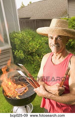 A man grilling in his backyard View Large Photo Image Stock Photo - A man grilling in his backyard. Fotosearch
