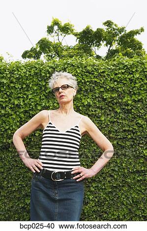 A middle-aged woman with her hands on her hips View Large Photo Image Stock Image - A middle-aged woman with her hands on her hips. Fotosearch