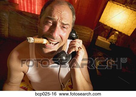 Stock Photograph - Man on the phone smoking a cigar. Fotosearch