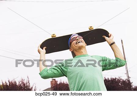 Middle-aged man with his skateboard View Large Photo Image Stock Photo - Middle-aged man with his skateboard. Fotosearch