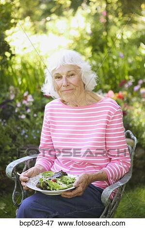 A senior woman eating a healthy salad View Large Photo Image Stock Photo - A senior woman eating a healthy salad. Fotosearch