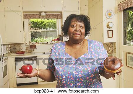 Woman deciding what to eat View Large Photo Image Stock Image - Woman deciding what to eat. Fotosearch