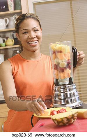 Woman making a blended fruit drink View Large Photo Image Stock Photo - Woman making a blended fruit drink. Fotosearch