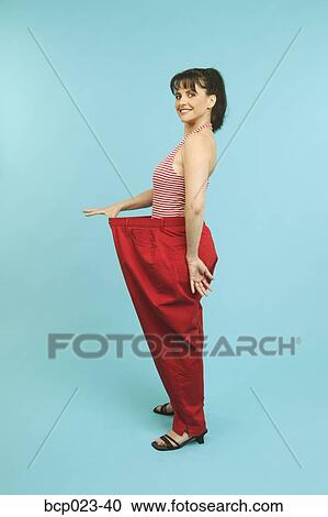 Woman wearing pants that are too big View Large Photo Image Stock Image - Woman wearing pants that are too big. Fotosearch