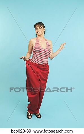 Stock Photo - Woman wearing pants that are too large. Fotosearch