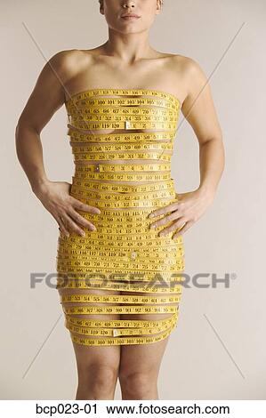 Standartiniai vaizdai - Young woman wrapped in measuring tape. Fotosearch