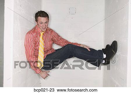 A young man caught between two walls View Large Photo Image Stock Image - A young man caught between two walls. Fotosearch