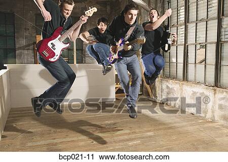 Four young men playing in a band View Large Photo Image Stock Image - Four young men playing in a band. Fotosearch