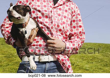 Stock Photo - Man holding a dog. Fotosearch