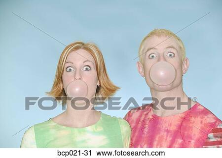 Stock Image - Young couple blowing bubbles with bubblegum. Fotosearch