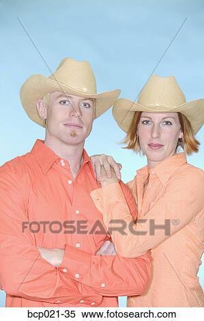 Stock Photography - Young couple wearing cowboy hats. Fotosearch