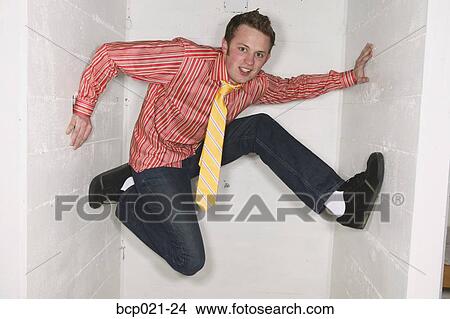 Young man trapped between walls View Large Photo Image Picture - Young man trapped between walls. Fotosearch